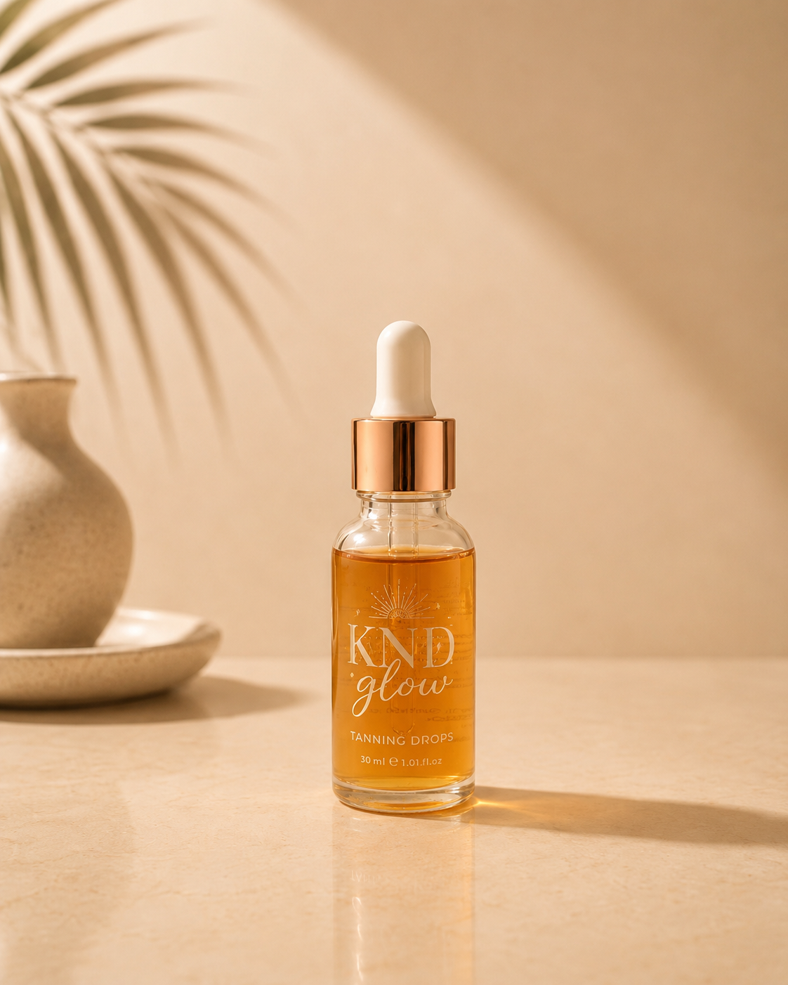 Kind Glow tanning drops bottle displayed on a beige surface with soft natural shadows.