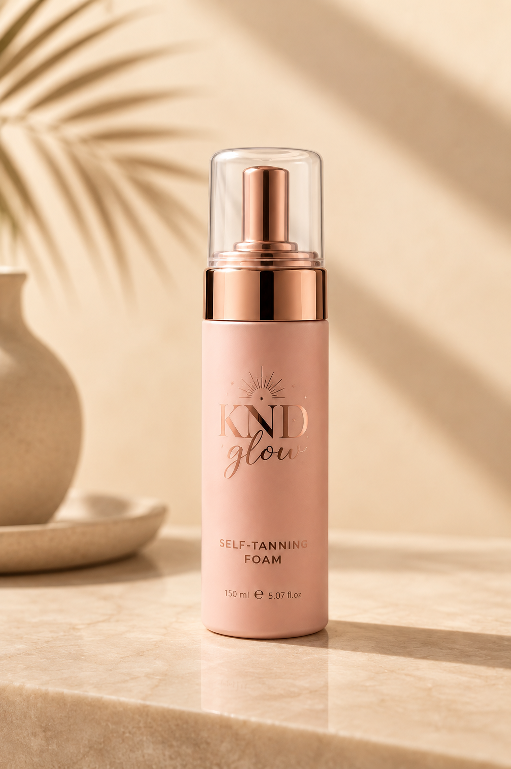 Bottle of KND Glow self-tanning foam on a beige background